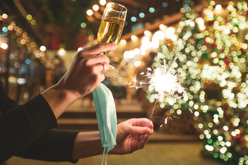 Medical mask in hands on a New Year's background, the concept of diseases and viruses. covid 19