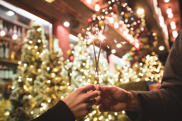 Two hands with sparklers on a Christmas or New Year's eve background