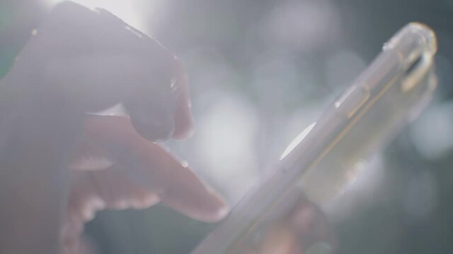 外でスマホを操作する人