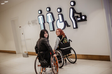 Two girls in wheelchairs go to a public toilet accessible to people with special needs