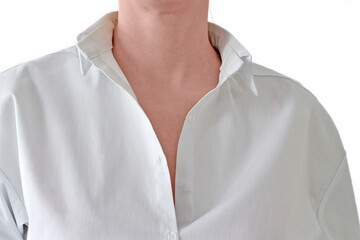 A white woman in a white shirt with her head cut off, only her neck is visible. On a white background close-up. The shirt with the collar is unbuttoned. Concept: businesswoman, clothing brand, doctor.