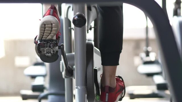 Close-Up of Feet Pedaling on Stationary Bike in Gym &ndash; Indoor Cycling Fitness Routine