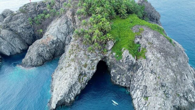 Aerial view in front of the Ilheu de Santana isle, near Sao Tome - tilt, drone shot