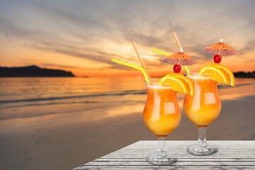 Tasty cocktail drinks with blur beach and sunset in background