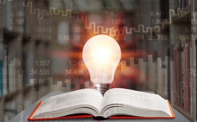 Light bulb and opened vintage book and Stock market or forex trading graph