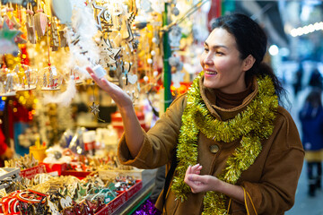Woman spending time at the fair and buying handmade Christmas decorations