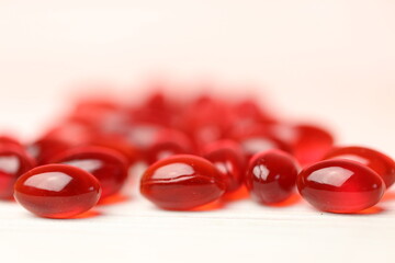 Krill oil red capsules set on a white wooden background .Natural supplements and vitamin.omega...