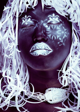 creative makeup like Ethiopian mask, white pattern on black face close up, halloween horror
