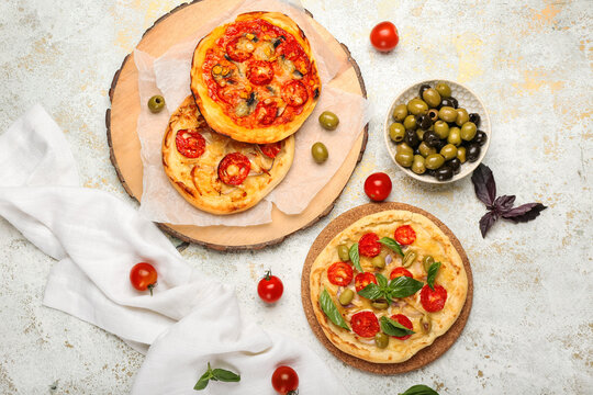 Composition with tasty mini pizzas and olives on light background