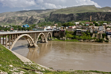Fototapeta na wymiar The Tigris River flows beneath an arched bridge in Hasankeyf, Eastern Anatolia, Turkey