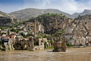 The Tigris River flows past the town, a mosque, and the remains of an old bridge and fortress in Hasankeyf, Eastern Anatolia, Turkey