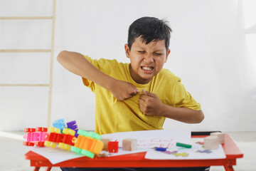 Emotional Tantrum and Angry boy while playing colorful bricks at home. Childhood traumatic...