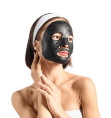 Young woman with activated charcoal mask on her face against white background