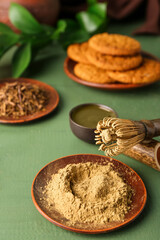 Plate with hojicha powder and bamboo chasen on color wooden background