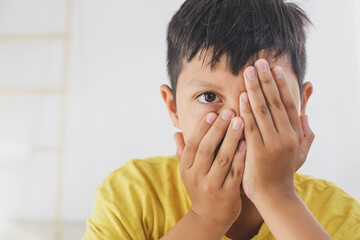 Boy closing his one eye in a protective position. Childhood traumatic experience, psychology,...
