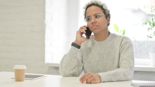 African Woman Talking on Smartphone in Office 