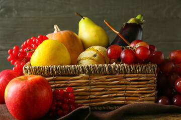 Basket with different healthy food on wooden table, closeup. Harvest festival