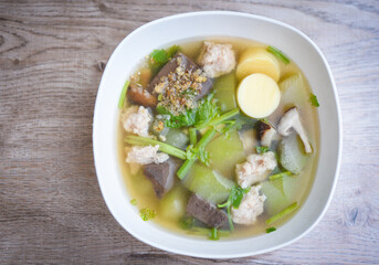 Clear soup blood pork thai healthy food asian on dark background, Tofu Soup bolw with winter melon vegetable eggs tofu slice meat ball and minced pork with celery, top view