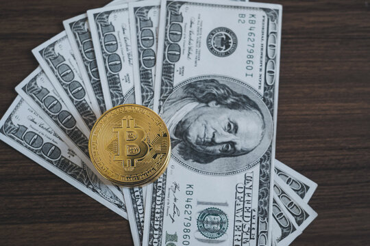 Golden bitcoin coin on us dollars close up. Bitcoin and cryptocurrency investing concept.