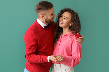 Happy young engaged couple on color background
