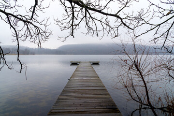 Naklejka na ściany i meble Valley Cottage, NY - USA - Dec. 11, 2021: a foggy horizontal winter view of the boat pier at Rockland Lake State Park in Rockland County, New York.