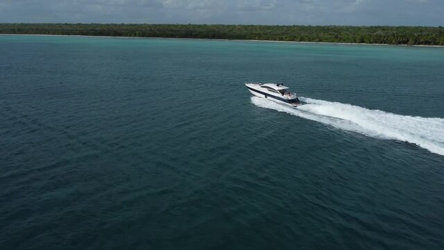 People on board of luxury motorboat sailing on caribbean sea of La Romana in Dominican Republic. Aerial approach