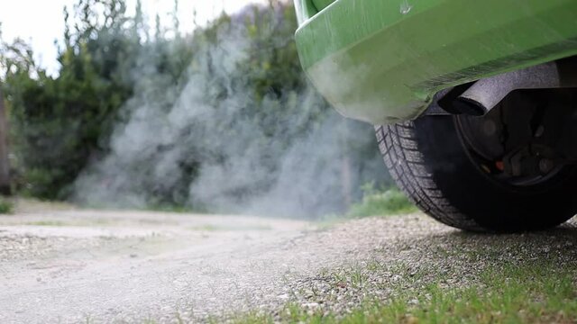 harmful toxic exhaust gas pollution - carbon monoxide, unburned hydrocarbons, nitrogen and sulfur oxides, carbonaceous particulate - rear view of a car with engine running - global warming risk
