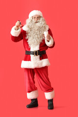 Santa Claus with Christmas bell and glass of milk on red background