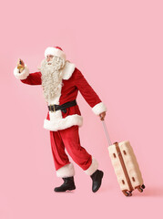 Santa Claus with Christmas bell and suitcase on pink background