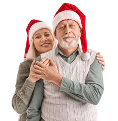 Happy mature couple in Santa hats on white background
