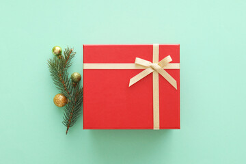 Composition with Christmas gift box, balls and fir branches on color background