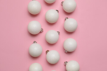 White Christmas balls on pink background, closeup