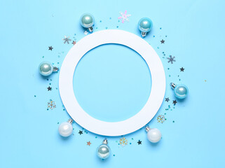 Composition with paper frame and Christmas decorations on blue background