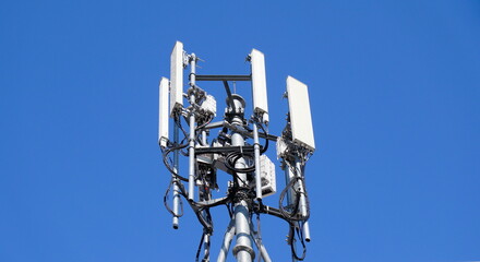 Telecommunication tower of 4G and 5G cellular. Macro Base Station. 5G radio network telecommunication equipment with radio modules and smart antennas mounted on a metal against blue sky background.