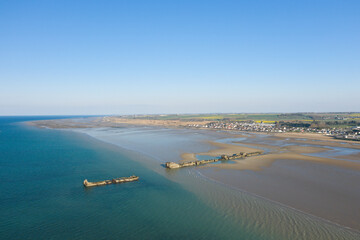 The huge artificial port of Gold beach in Asnelles at low tide in Europe, France, Normandy, Arromanches les Bains, in summer, on a sunny day.