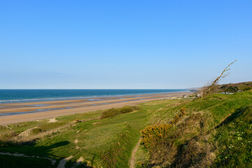 Fototapeta na wymiar Omaha beach seen from steep cliffs in Europe, France, Normandy, towards Arromanches, Colleville, in spring, on a sunny day.
