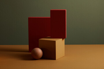 Red and orange podium with wooden sphere in a grey background for abstract advertising , front view