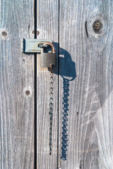 Vintage Rusted Padlock and hasp on Weathered Gray Wood Doors