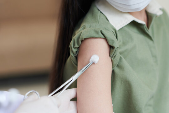 Girl In Medical Mask Getting Site On His Arm Disinfected Before Getting Vaccine Against Coronavirus