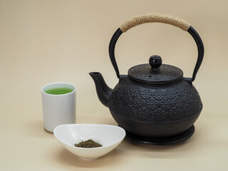 Cup of Fresh Green Tea with Black Cast Iron Teapot