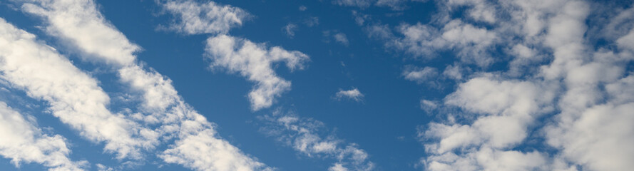 Dramatic cloudscape with fast moving white clouds against a blue sky, as a nature background
