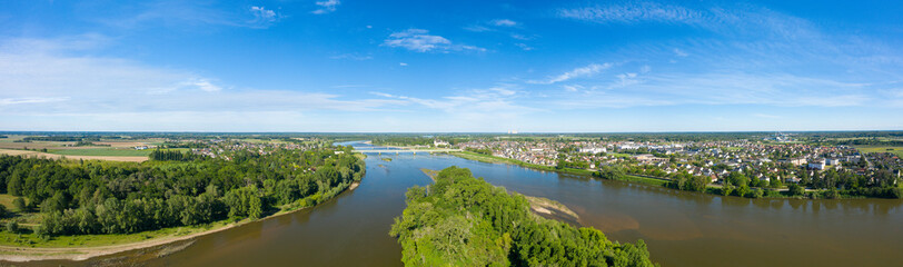 The panoramic view of the city of Sully sur Loire and its river in Europe, in France, in the Center region, in the Loiret, in summer, on a sunny day.