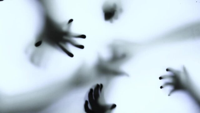 Silhouette of a zombie hand on white background in slow motion
