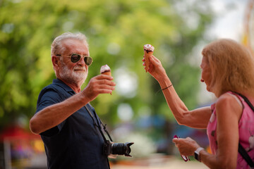 Fototapeta premium elderly senior couple woman and man having fun and happy together at amusement them park