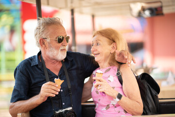elderly senior couple woman and man having fun and happy together at amusement them park