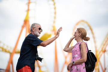 Obraz premium elderly senior couple woman and man having fun and happy together at amusement them park