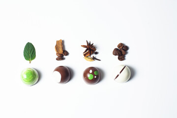 Mexican colorful chocolate candy bonbons with mint leaves, cinnamon and coffee beans on white background