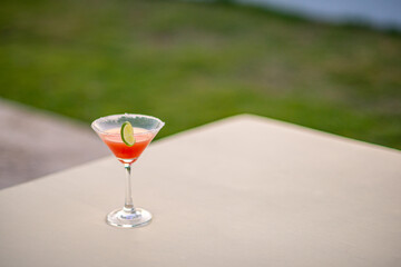 A glass of alcohol cocktail, lime and salt on the table with copy graphics space