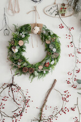 白い壁に飾られたリースとサンキライ