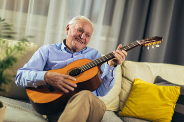 Senior man playing guitar at home